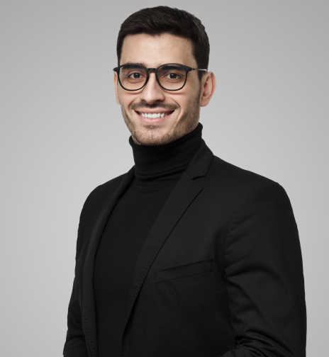 A man wearing glasses and a black turtleneck sweater, exuding a sophisticated and intellectual appearance.